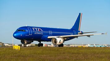 A large blue airplane is on the runway