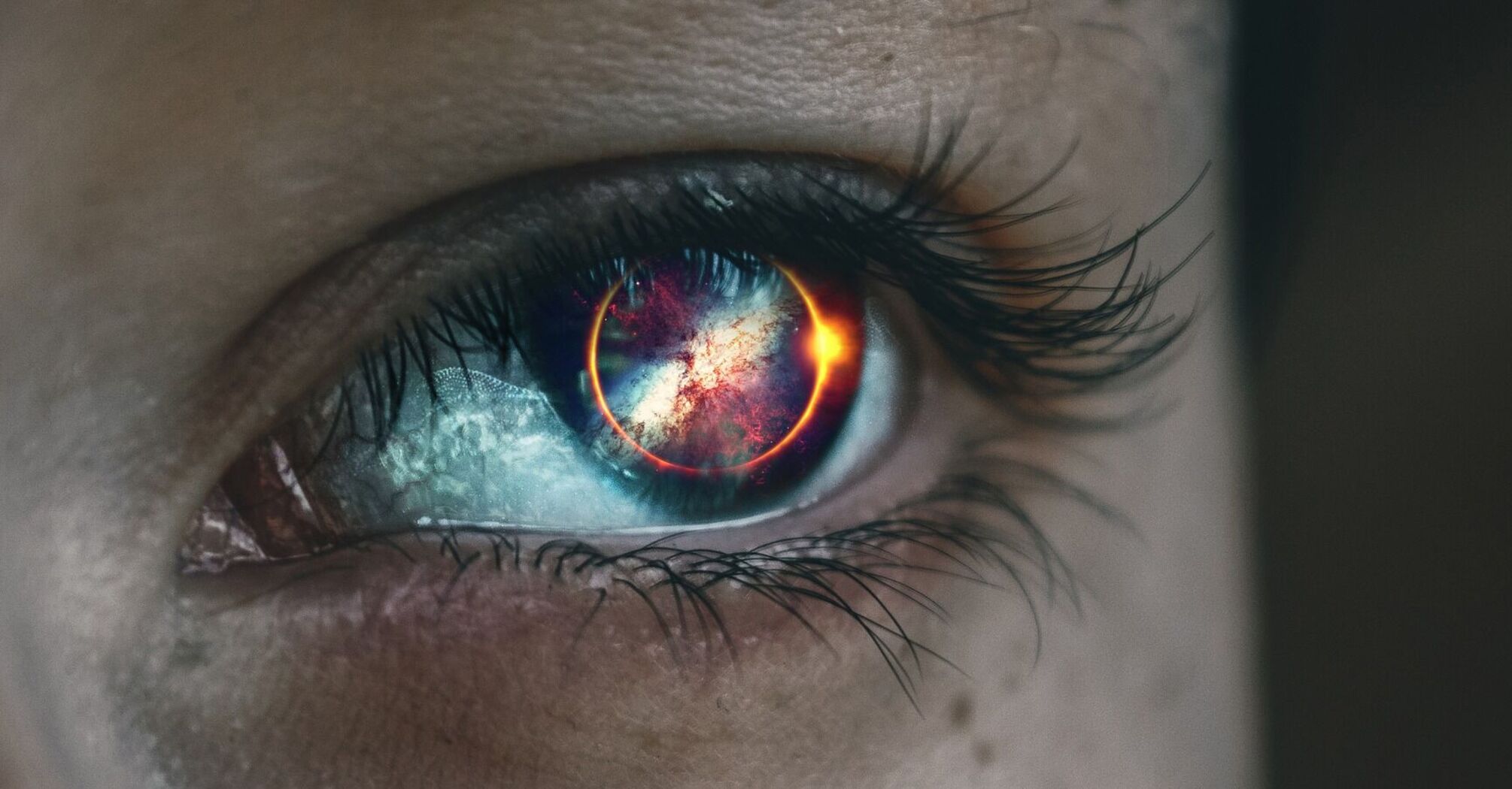 Close-up of an eye with a solar eclipse reflected in the pupil
