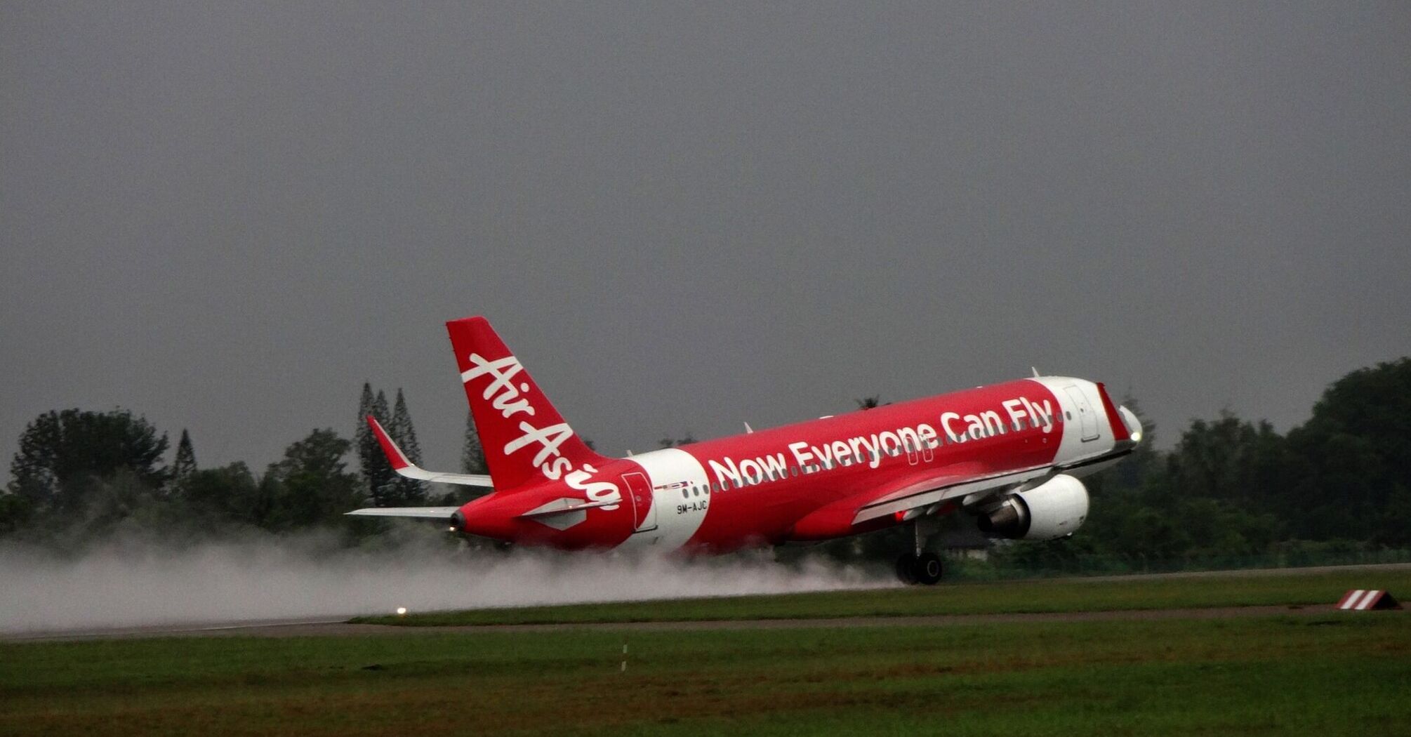 AirAsia aircraft taking off on a wet runway