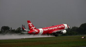 AirAsia aircraft taking off on a wet runway