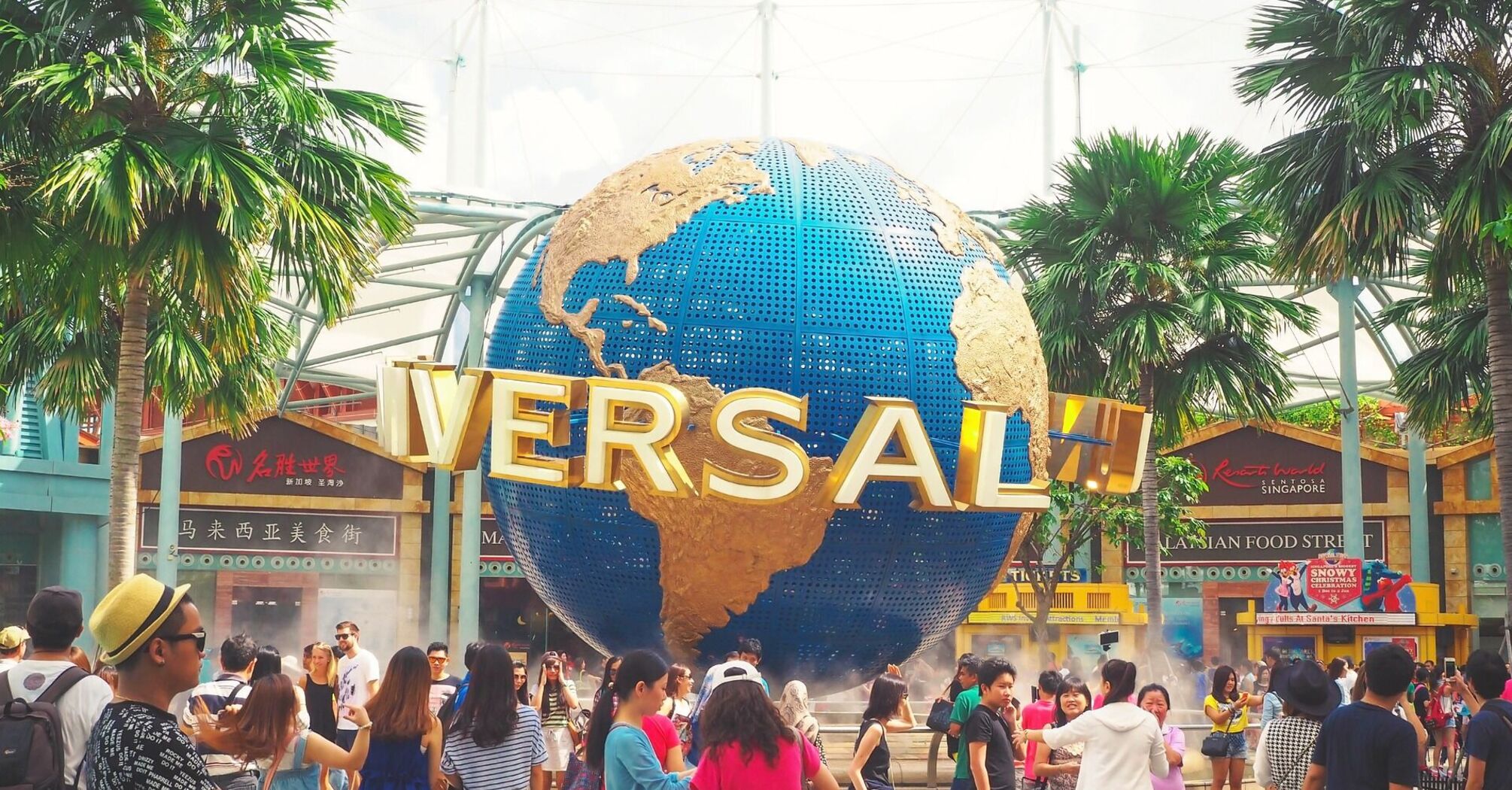 Crowd of visitors at the entrance of Universal theme park with the iconic rotating globe