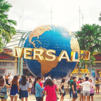 Crowd of visitors at the entrance of Universal theme park with the iconic rotating globe