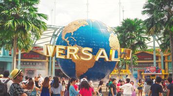 Crowd of visitors at the entrance of Universal theme park with the iconic rotating globe