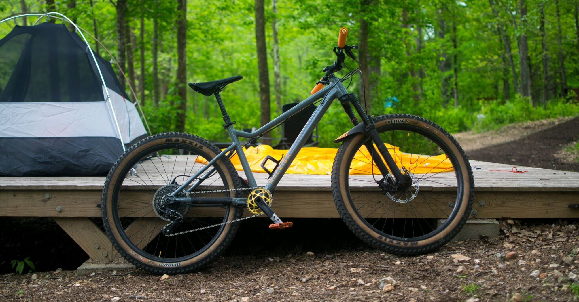 A bicycle parked on a wooden platform in the woods