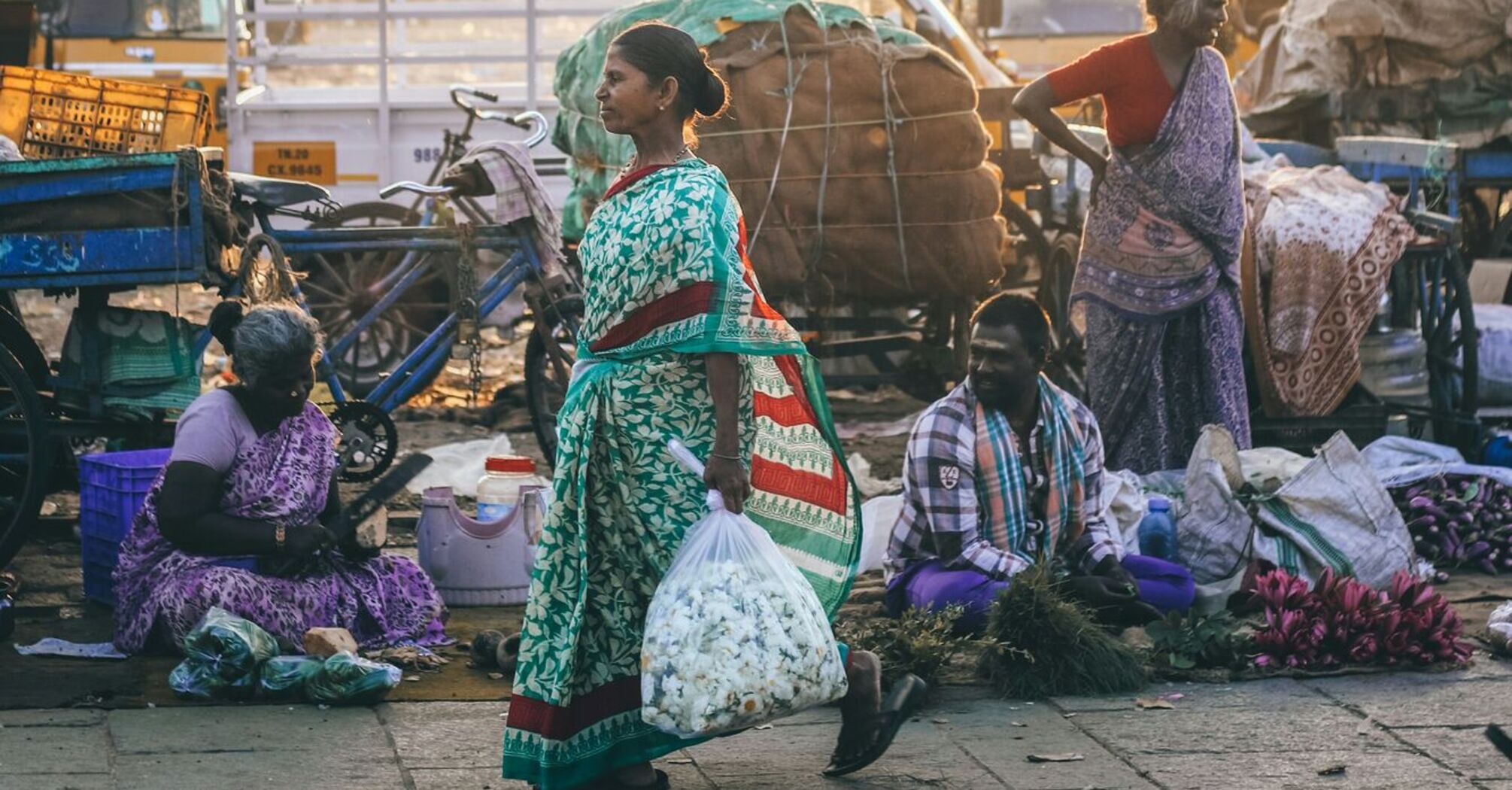 Woman wearing green and red sari dress walking on road