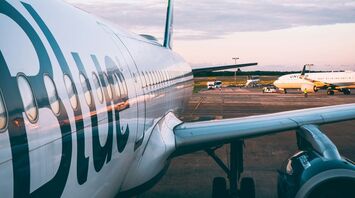 JetBlue aircraft on the tarmac during twilight, showcasing the airline's branding on the fuselage