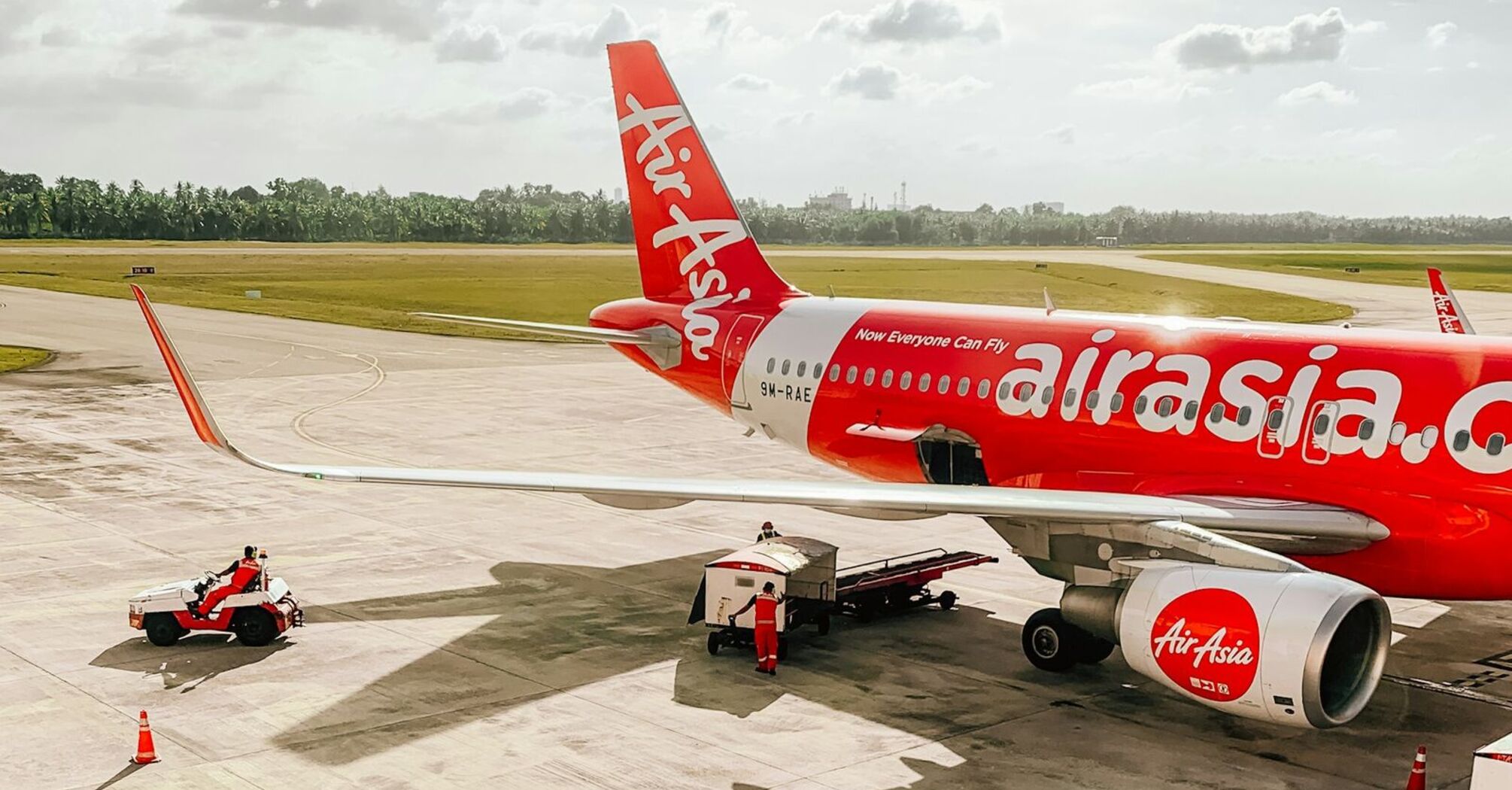 An AirAsia aircraft on the tarmac, with clear skies in the background