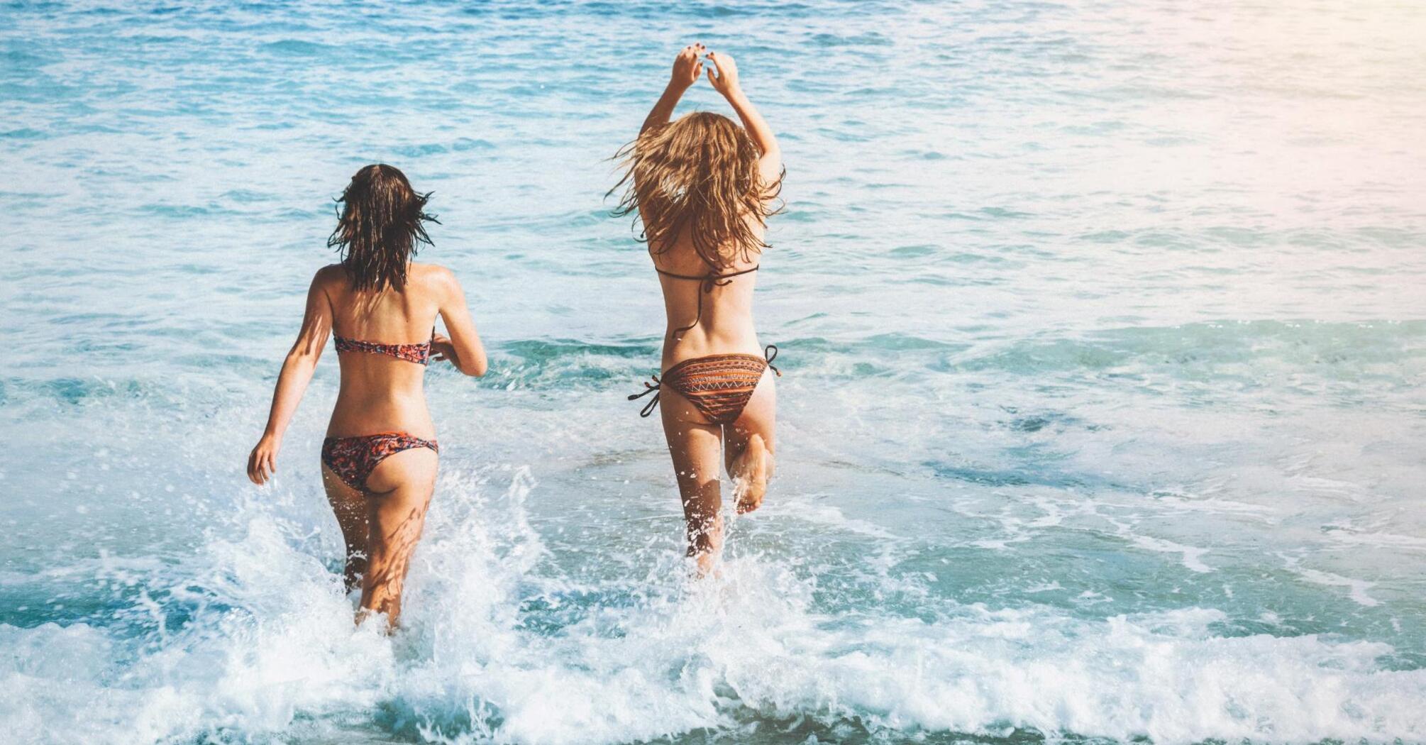 Two girls are swimming on the beach