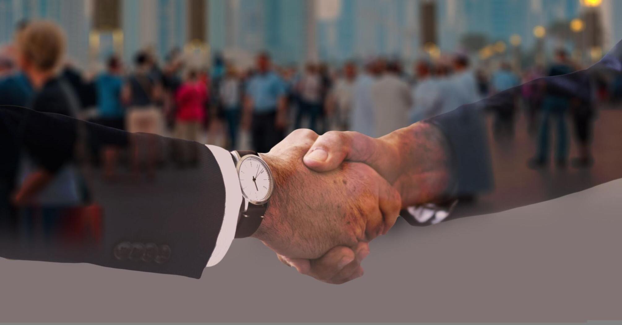 Handshake of two men against the backdrop of city bustle