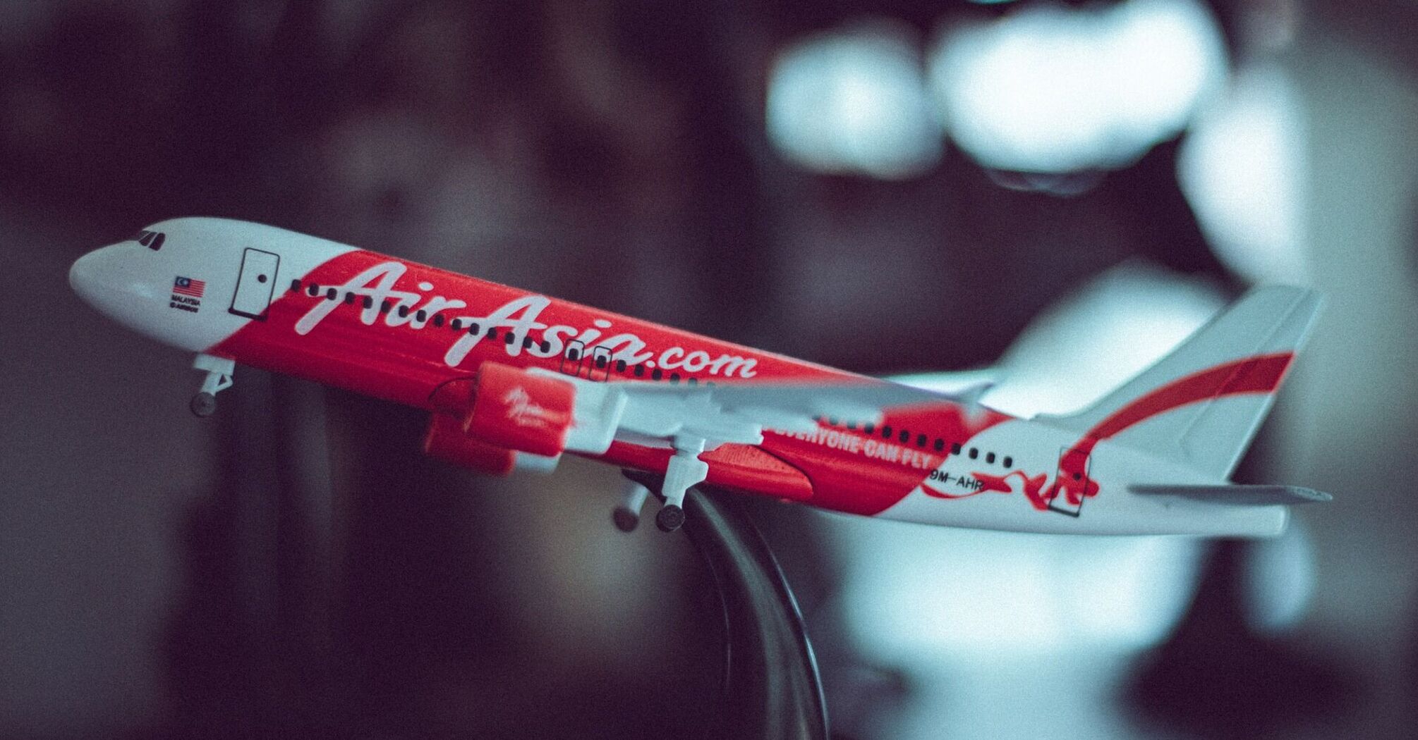 Model of an AirAsia airplane on a stand with 'AirAsia.com' and 'Now everyone can fly' written on the side 