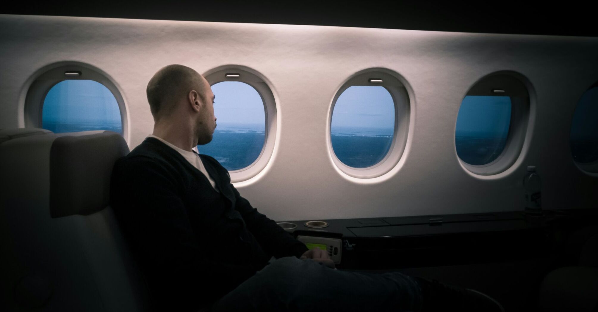 Passenger contemplating the view from the spacious cabin of a business class section in an airplane