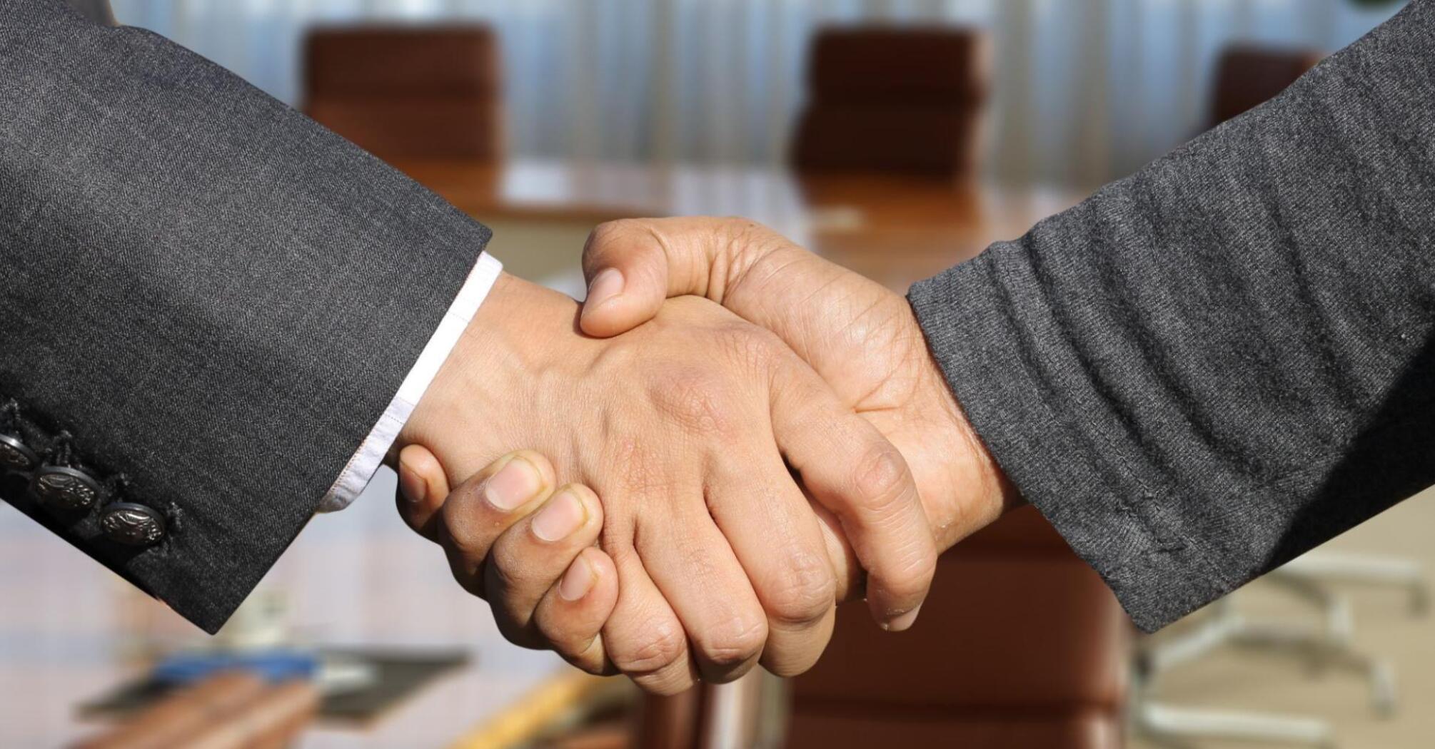 Two men in suits shaking hands
