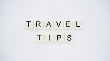Scrabble tiles spelling out 'TRAVEL TIPS' on a white background