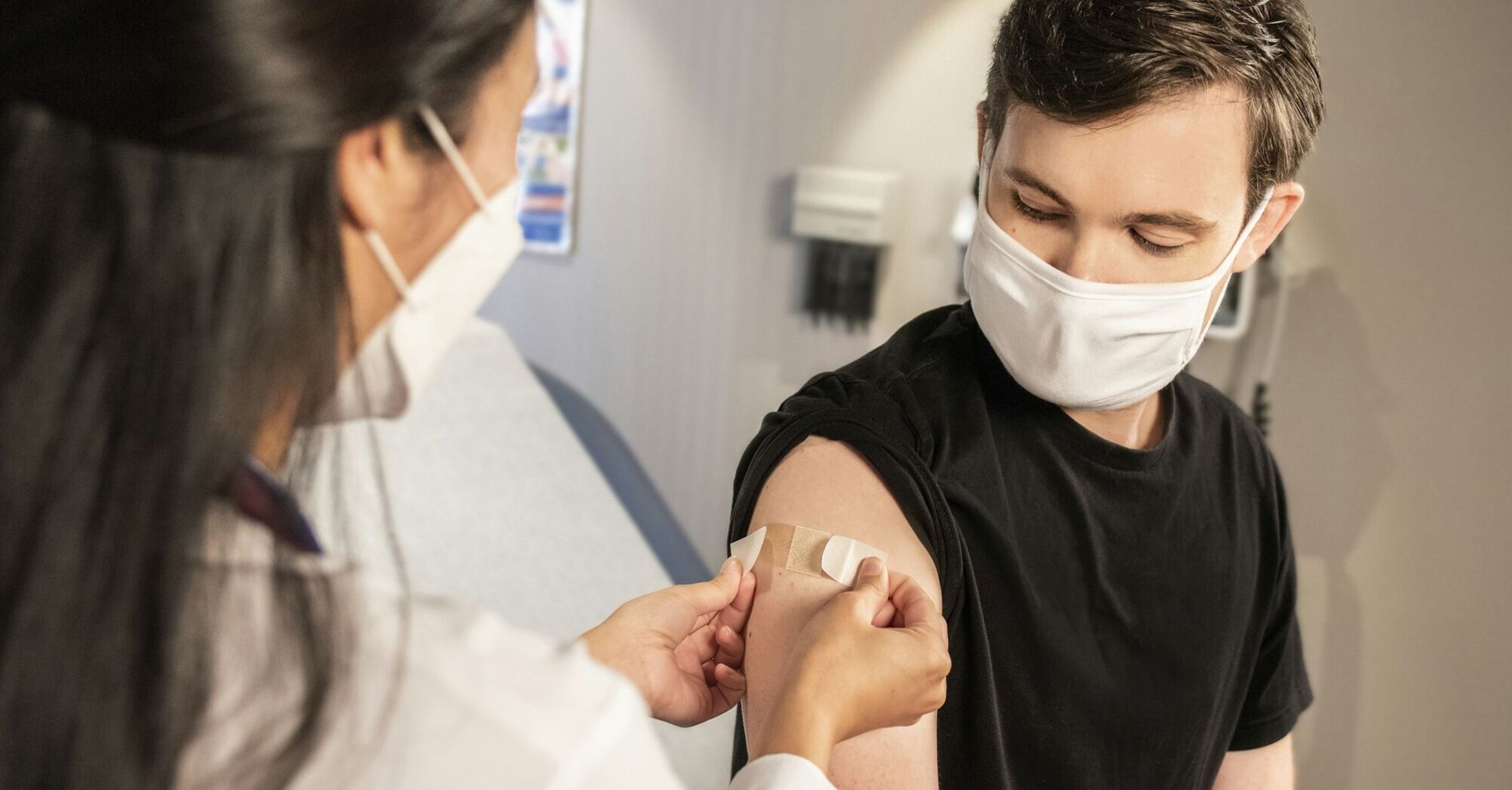 Healthcare professional applying bandage after vaccination