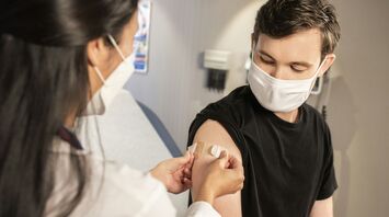 Healthcare professional applying bandage after vaccination