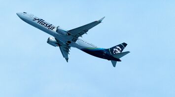 A large passenger jet flying through a blue sky
