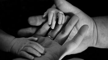 A black and white image showing the hands of a family