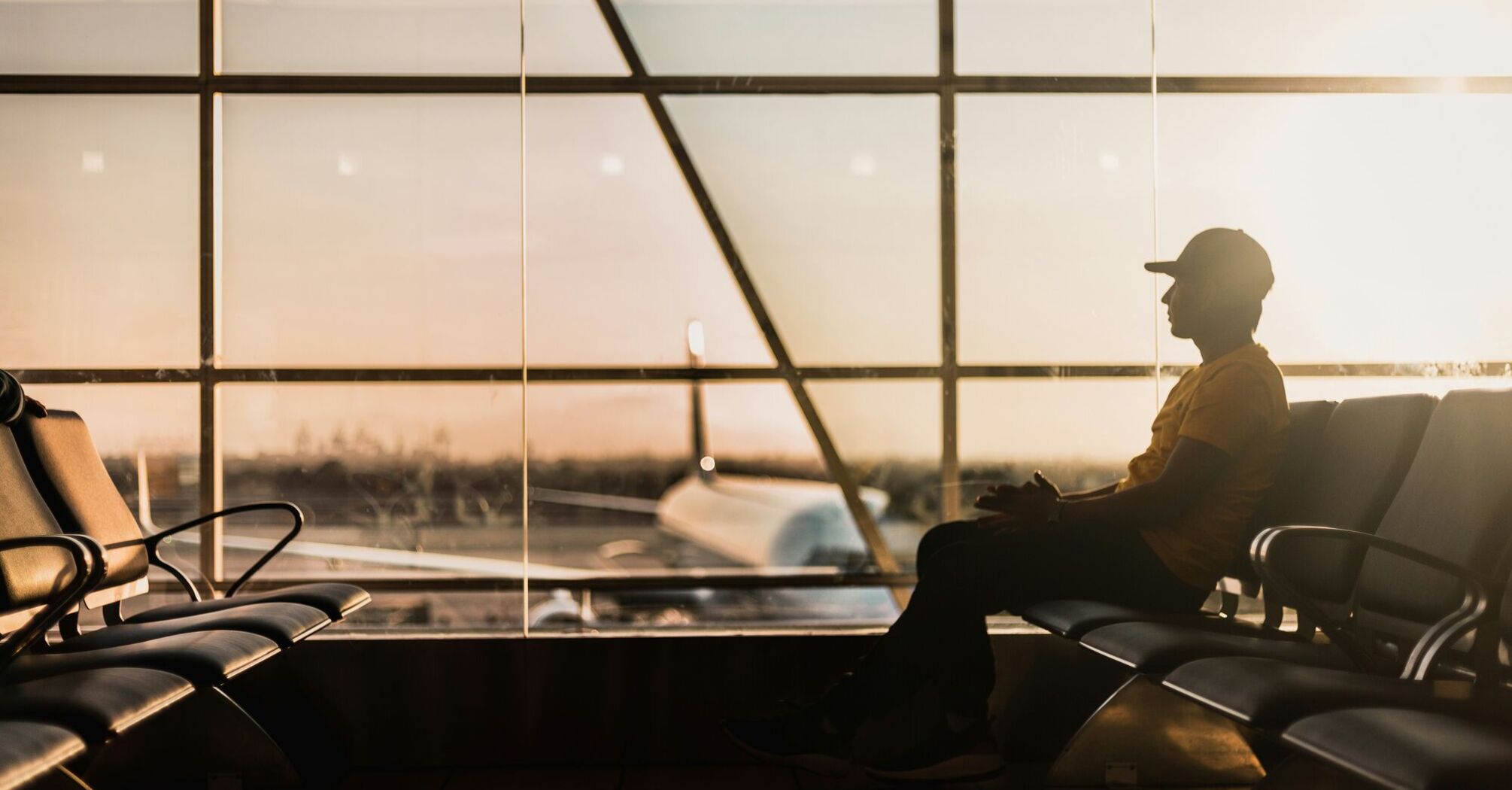 Person sitting in airport terminal at sunset