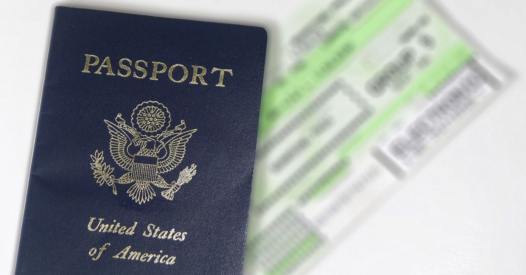 American passport with blurred airline tickets in the background