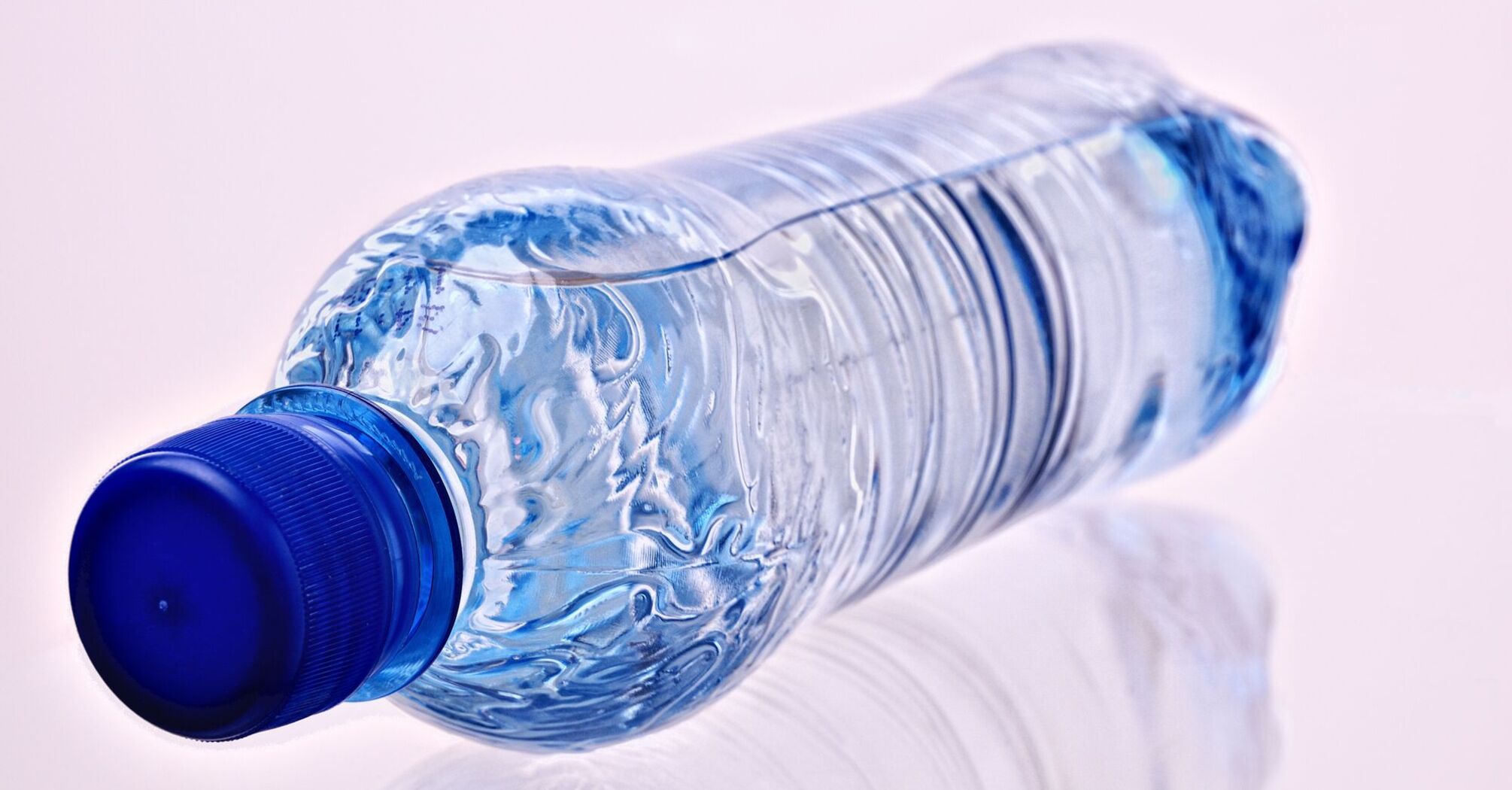 A plastic water bottle with a blue cap