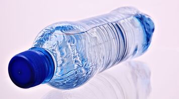 A plastic water bottle with a blue cap