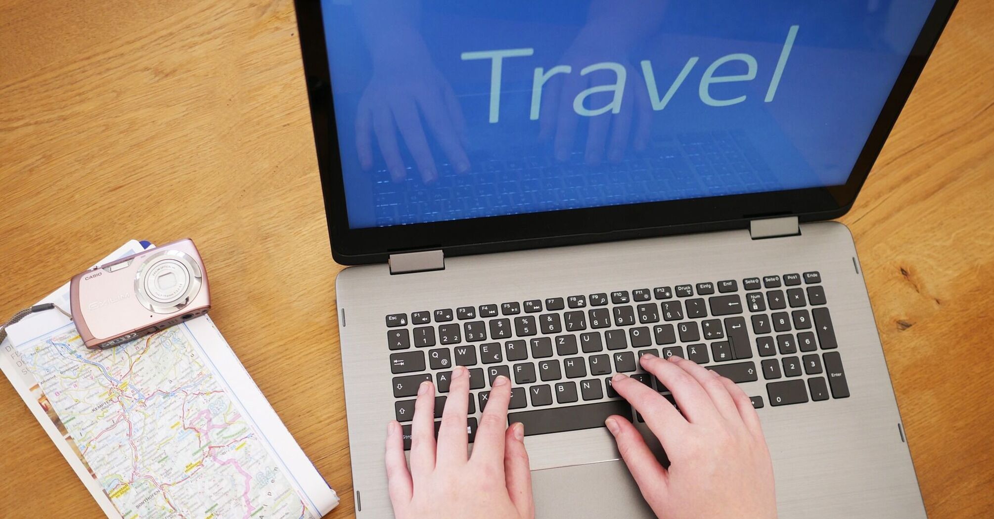 Travel planning with laptop, camera, watch, and map