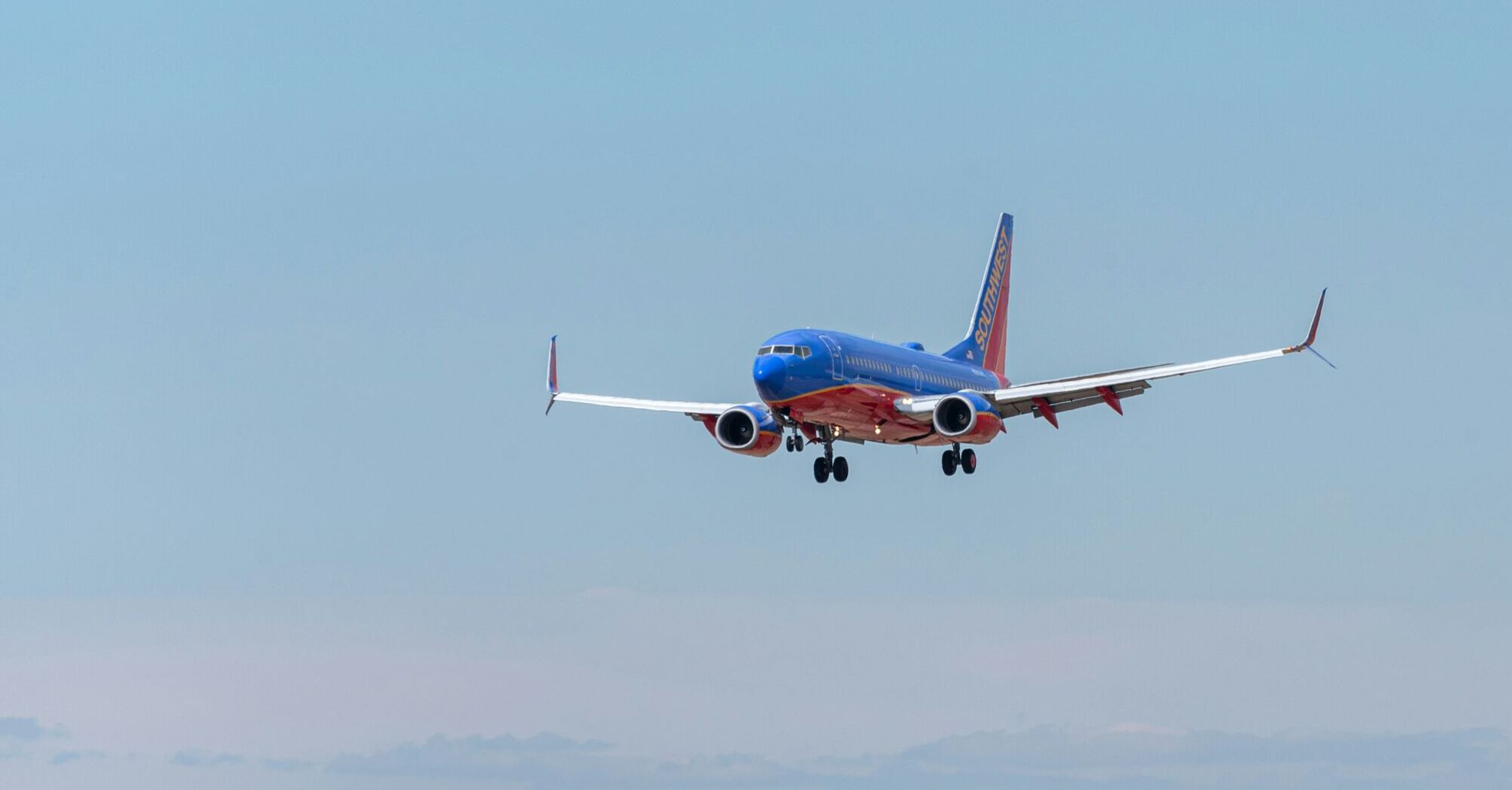 Blue and red passenger plane flying during daytime