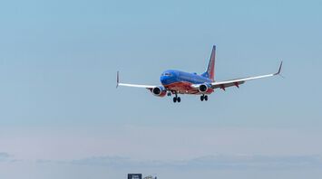 Blue and red passenger plane flying during daytime