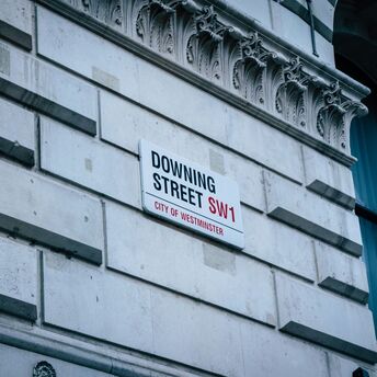 Street sign 'Downing Street SW1' on the wall of a building in the City of Westminster, London