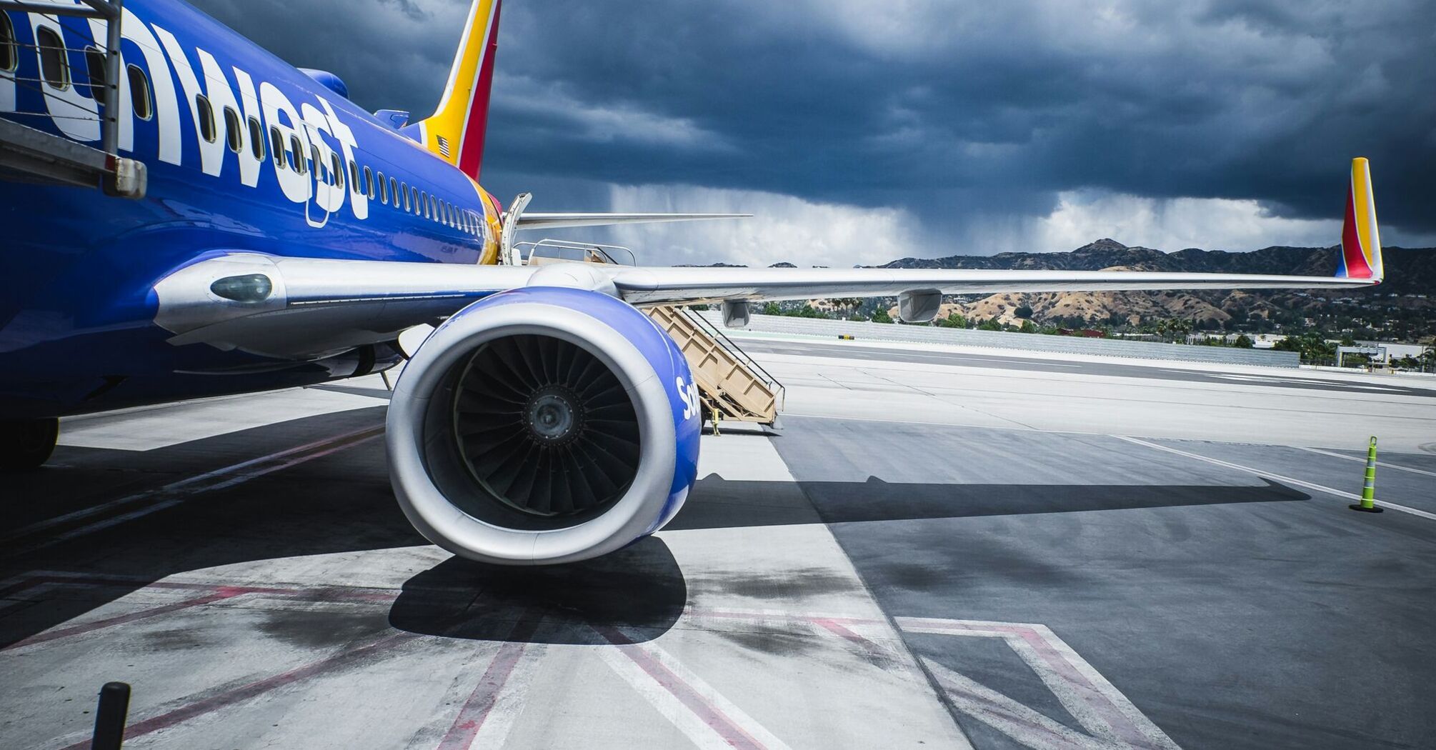 A Southwest Airlines plane on the ground, against a backdrop of stormy skies