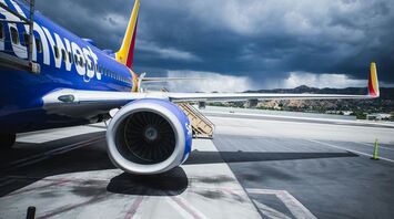 A Southwest Airlines plane on the ground, against a backdrop of stormy skies