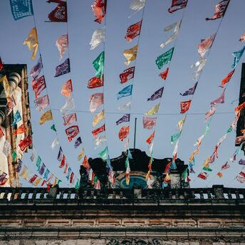 Colorful papel picado streamers fluttering above a Mexican street