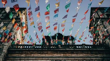 Colorful papel picado streamers fluttering above a Mexican street