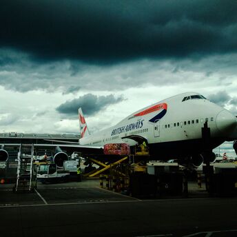 White and red airplane with cumulonimbus cloud