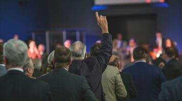 People at a gathering raising their hands in a sign of participation or agreement