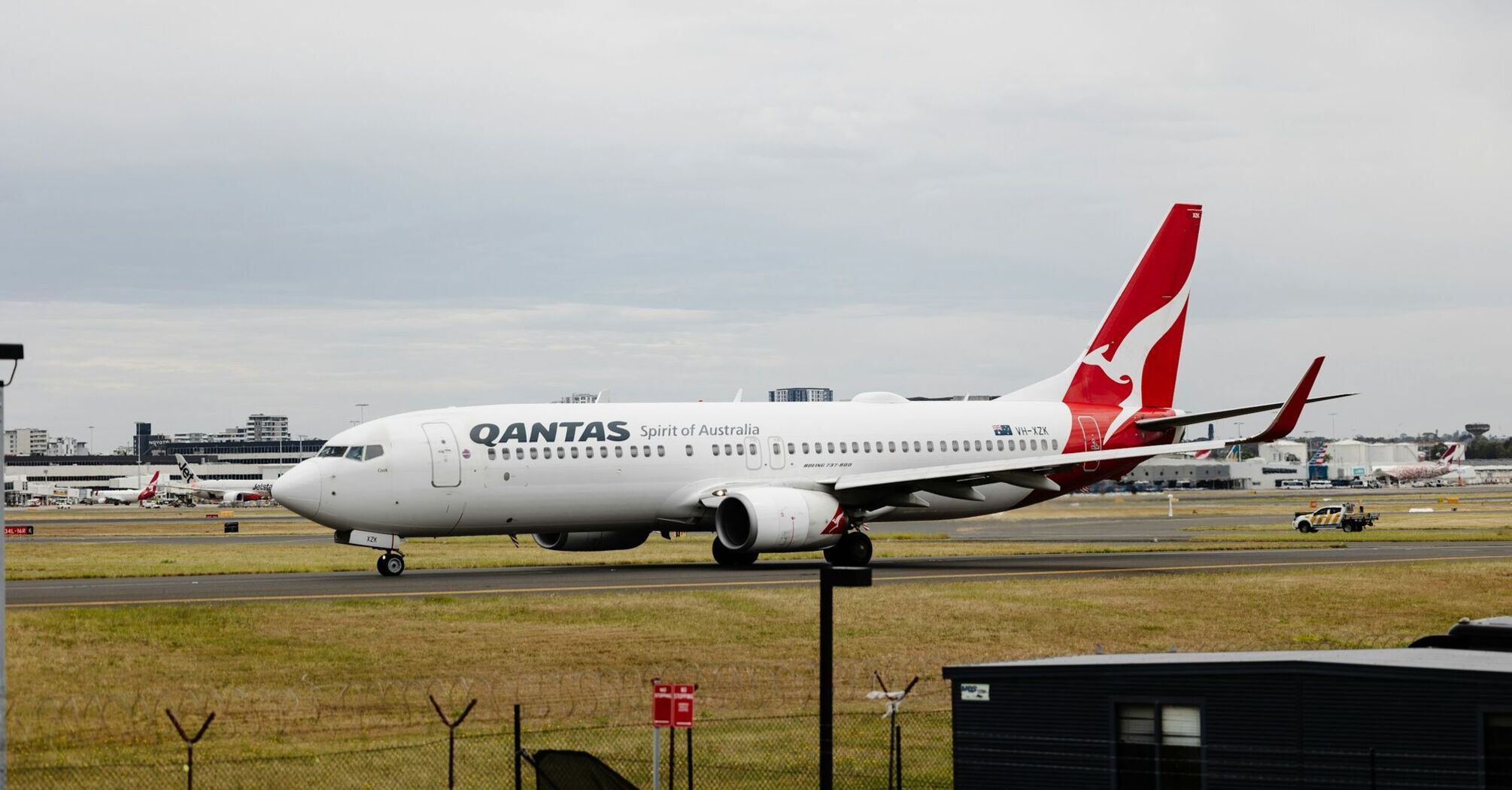 Qantas airplane on the runway with other aircraft in the background