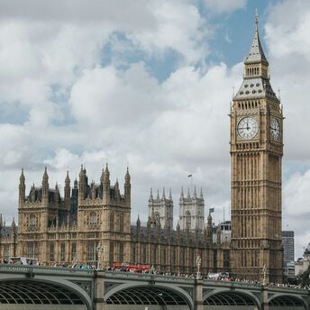 A view of the iconic Big Ben and the Houses of Parliament in London, with Westminster Bridge in the foreground