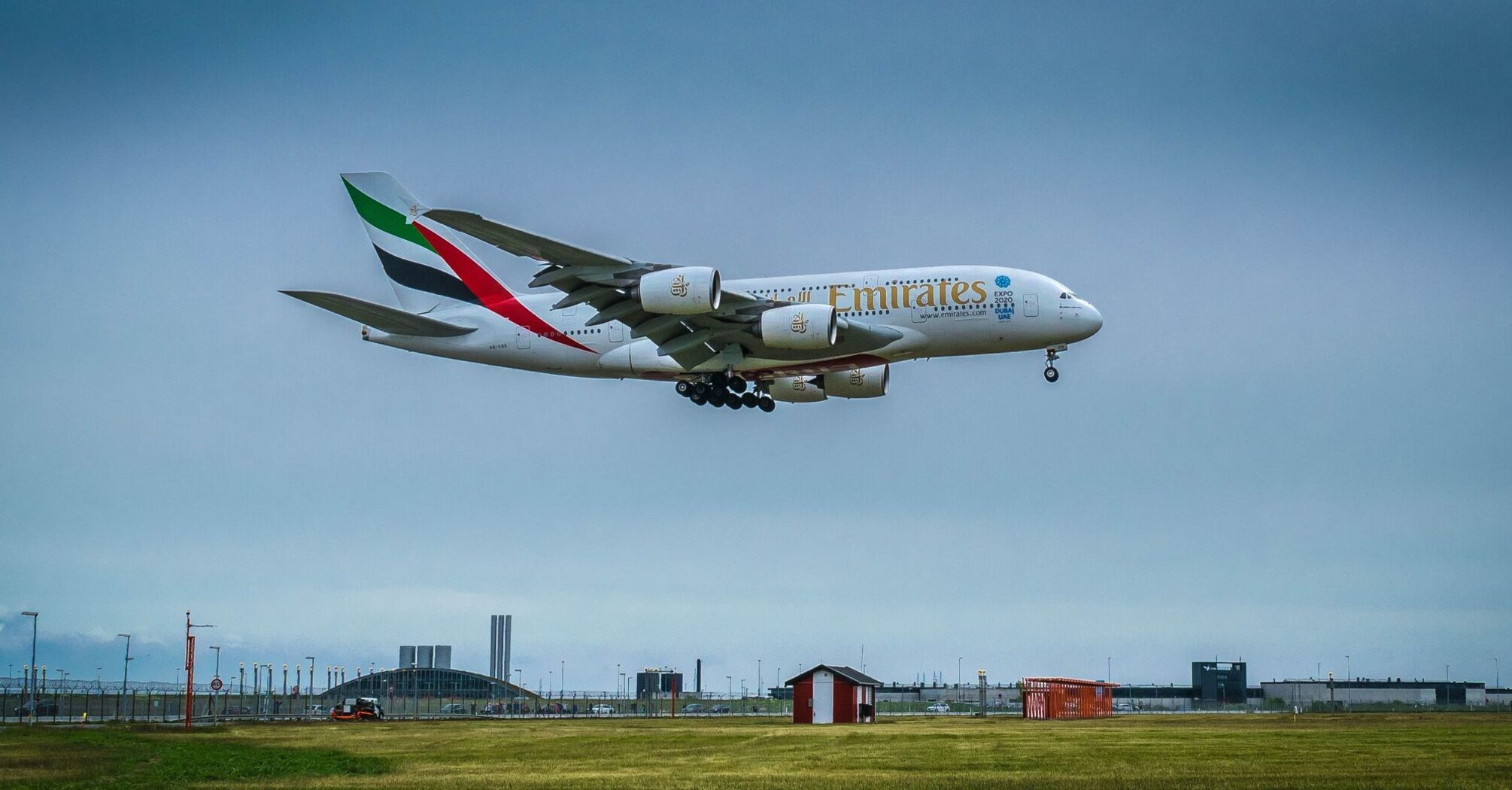 Emirates Airbus A380 approaching landing against a cloudy sky