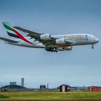 Emirates Airbus A380 approaching landing against a cloudy sky