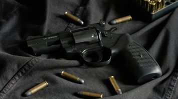 Revolver and bullets on a dark fabric background