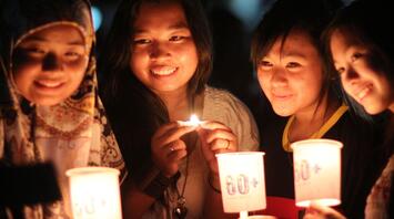 Girls sitting with lit candles