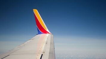 Wing of a Southwest Airlines plane in flight against a clear blue sky