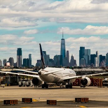 Newark Liberty International Airport with a plane on the tarmac and New York City skyline in the background
