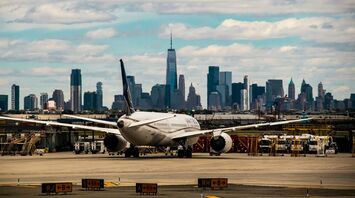 Newark Liberty International Airport with a plane on the tarmac and New York City skyline in the background