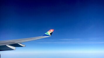 White and red airplane wing over blue sky during daytime