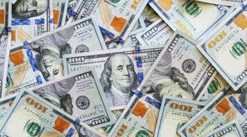 Scattered hundred dollar bills in various orientations
