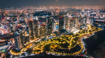 Aerial view of Mexico City at night, showcasing illuminated skyscrapers and busy streets