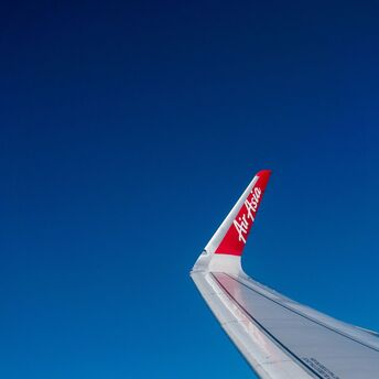 AirAsia airplane wing against a clear blue sky