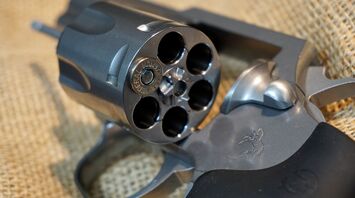 Close-up of a loaded revolver showing bullets in chambers