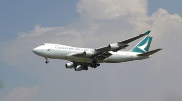 A large jetliner flying through a cloudy blue sky